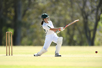 A Young Girl Plays A Shot While Batting In A Game Of Cricket